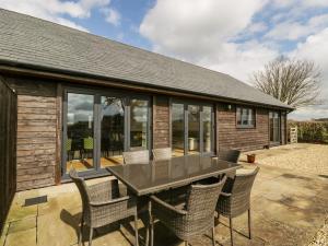 a house with a table and chairs on a patio at Rectory Farm Lodge in Queen Camel