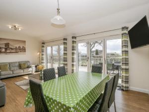 a dining room with a green table and chairs at Rectory Farm Lodge in Queen Camel