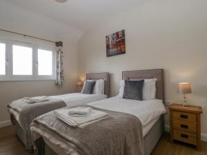2 camas individuales en una habitación con ventana en Rectory Farm Lodge en Queen Camel