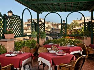 ein Restaurant mit roten Tischen und Stühlen auf einer Terrasse in der Unterkunft Albergo Ottocento in Rom