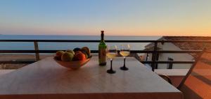 a table with a bowl of fruit and two glasses of wine at Glyfada Seaview Home 126 by New Era in Glyfada +25 photos