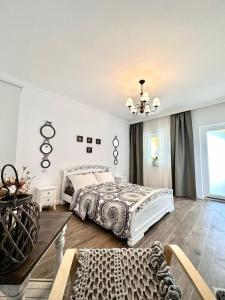 1 dormitorio con cama y lámpara de araña en Alma Rezidence, en Turda
