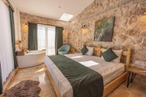 a bedroom with a large bed and a bath tub at Soleado Cappadocia Hotel in Uçhisar