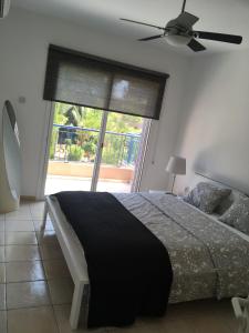 a bedroom with a bed and a large window at Limnaria Villas Kato Paphos - wonderful villa near the beach and all facilities in Paphos City