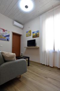 ein Wohnzimmer mit einem Sofa und einem TV in der Unterkunft Kosentia Bed and Breakfast in Cosenza