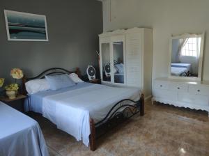 a bedroom with a bed and a dresser and mirror at Destiny Palms Apt in Belle Air Summit