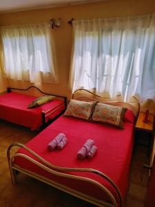 1 dormitorio con 2 camas y zapatillas en Descanso en casa de familia en Salta