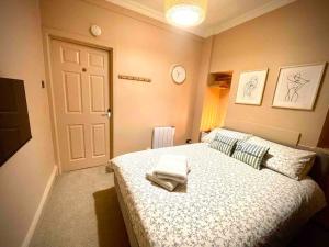 a bedroom with a bed with two towels on it at Newly refurbished, central apartment with permit parking in Bath