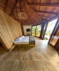 una camera con letto in una stanza con soffitti in legno di Finca Hotel Tierra Verde a Belén