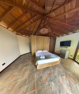 a bedroom with a bed and a wooden ceiling at Finca Hotel Tierra Verde in Belén