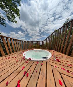 bañera de hidromasaje en una terraza de madera con pétalos rojos en el suelo en Finca Hotel Tierra Verde en Belén