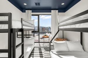 a dorm room with bunk beds and a balcony at The Eighteen by Locale in Nashville