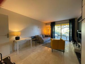 salon z kanapą i stołem w obiekcie C012-Appartement confortable avec piscine, tennis et grand parc w Cannes