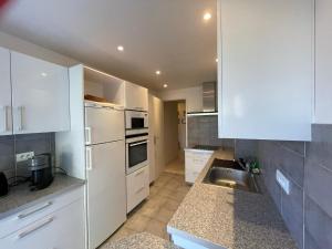kuchnia z białymi szafkami i zlewem w obiekcie C012-Appartement confortable avec piscine, tennis et grand parc w Cannes