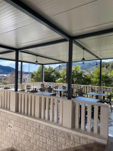 un patio con mesas y sillas y montañas de fondo en Marin San, en Mokošica