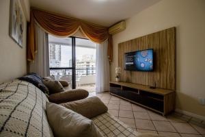 uma sala de estar com um sofá e uma televisão de ecrã plano em BK91 - Próx Calçadão, Sacada, 3 Dorm, Garagem em Balneário Camboriú