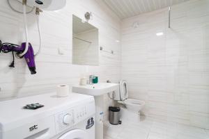 Baño blanco con lavabo y aseo en High-End Spacious Apartment next to City Mall, en Skopje