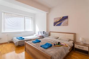 1 dormitorio con 2 camas y toallas azules. en High-End Spacious Apartment next to City Mall, en Skopje