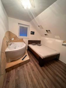 a bathroom with a bed and a bath tub and a sink at Magika in Uherský Brod