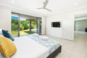 ein weißes Schlafzimmer mit einem großen Bett und einem TV in der Unterkunft Family Paradise;Elegant 4BR King bed; Pool and BBQ in Trinity Beach