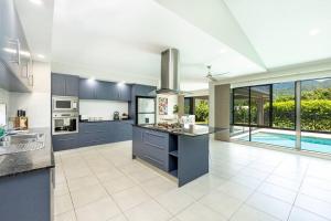 uma cozinha com armários azuis e uma piscina em Family Paradise;Elegant 4BR King bed; Pool and BBQ em Trinity Beach