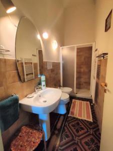 een badkamer met een wastafel, een toilet en een spiegel bij Panoramic Apartment in Villa on The Beach, In Center in Agropoli