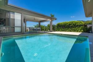 uma piscina em frente a uma casa em Family Paradise;Elegant 4BR King bed; Pool and BBQ em Trinity Beach