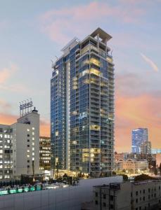 a tall building with lights on in a city at Level Downtown LA South Olive in Los Angeles