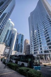a bus is parked in a city with tall buildings at We love having you here in Abu Dhabi