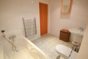 a bathroom with a tub and a toilet and a sink at Town or Country - The Greenwich in Southampton