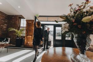 a man and a woman standing in a room with a table at The Chandler Hotel in Madison