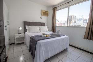 Un dormitorio con una cama con una bandeja de comida. en CLR83 - Calçadão, 1 Dorm Climatizado, Garagem, en Balneário Camboriú