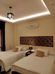 1 dormitorio con 2 camas y lámpara de araña en Relax Guest House, en Seis de Octubre