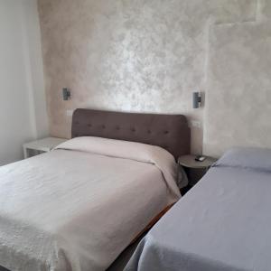 マルゲリータ・ディ・サヴォイアにあるSweet Suite Margherita B&Bのベッドルーム1室(ベッド2台、ナイトスタンド2台付)