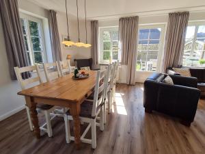 a dining room with a wooden table and chairs at Ferienhaus Ellen, EG Whg in Utersum +11 photos