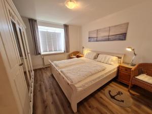 a bedroom with a large bed and a window at Ferienhaus Ellen, EG Whg in Utersum