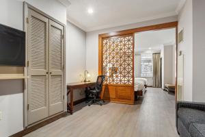 a hotel room with a desk and a bed and a bedroom at Wyndham Garden Baronne Plaza in New Orleans