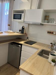 uma pequena cozinha com um lavatório e um micro-ondas em Appartement confortable Olympic games JO24 em Aubervilliers