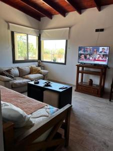 salon z kanapą i telewizorem w obiekcie Casa en Santa Rosa de Calamuchita w mieście Santa Rosa de Calamuchita