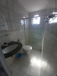 a bathroom with a shower and a toilet and a sink at Hotel Aurora in Alagoinhas