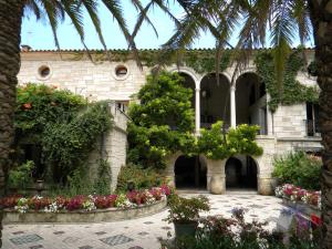 un bâtiment avec des fleurs et des plantes dans une cour dans l'établissement les arbousiers, à Céret