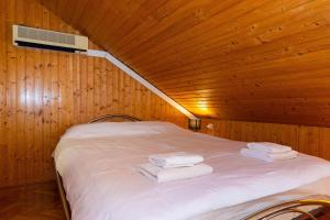 a bed in a wooden room with towels on it at Apartment Kekia in Dubrovnik