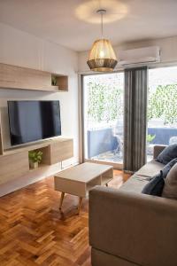 sala de estar con sofá y TV de pantalla plana en Departamento en peatonal Mendoza en Mendoza