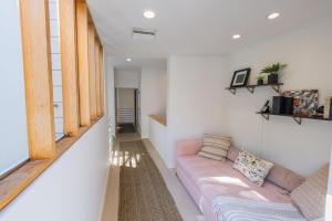 a living room with a pink couch and a window at The Butterfly House in Malibu +17 photos