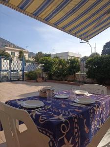 a table with a blue and white table cloth on a patio at Casa delle Sirene in Isola delle Femmine