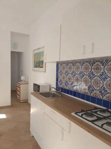 a kitchen with a sink and a counter top at Casa delle Sirene in Isola delle Femmine