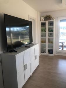 a living room with a flat screen tv on a white entertainment center at Apartamento 3 habitaciones Miramar, Luanco in Luanco