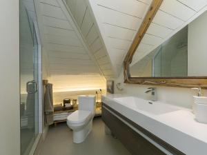 a bathroom with a toilet and a sink and a mirror at 338 - Le Quai des Veuves - Les Immeubles Charlevoix in Baie-Saint-Paul +10 photos