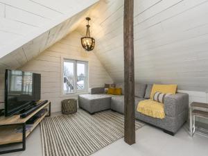 a living room with a couch and a tv at 338 - Le Quai des Veuves - Les Immeubles Charlevoix in Baie-Saint-Paul