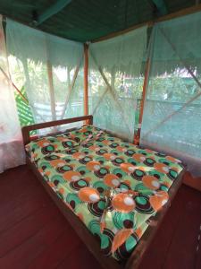 a small bed in a room with aocemetery at Hostal Búho Amazonas tours in Leticia